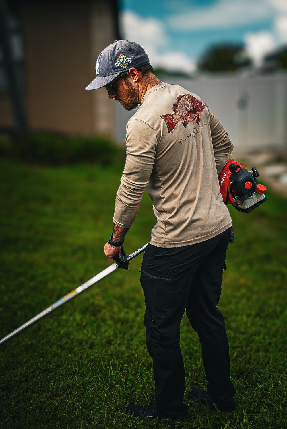 Crew member edging along the grass with a trimmer